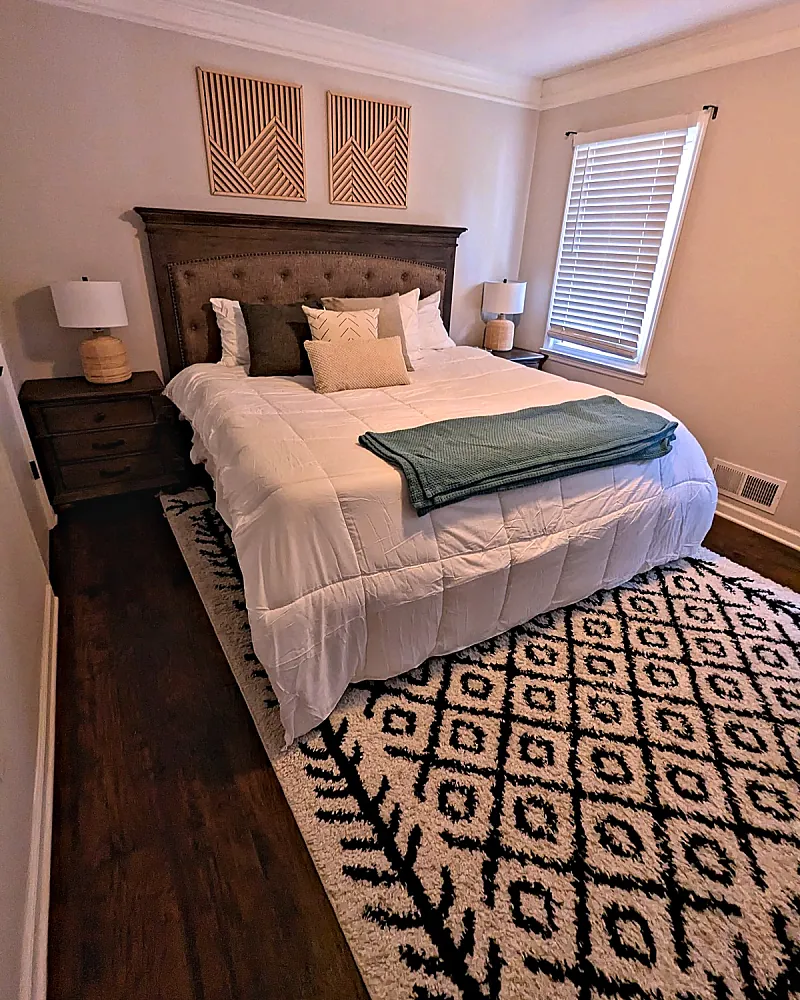 Made-up bedroom with a patterned rug