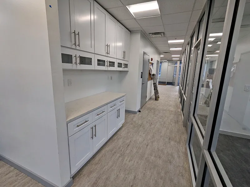 Bright office hallway with white cabinets